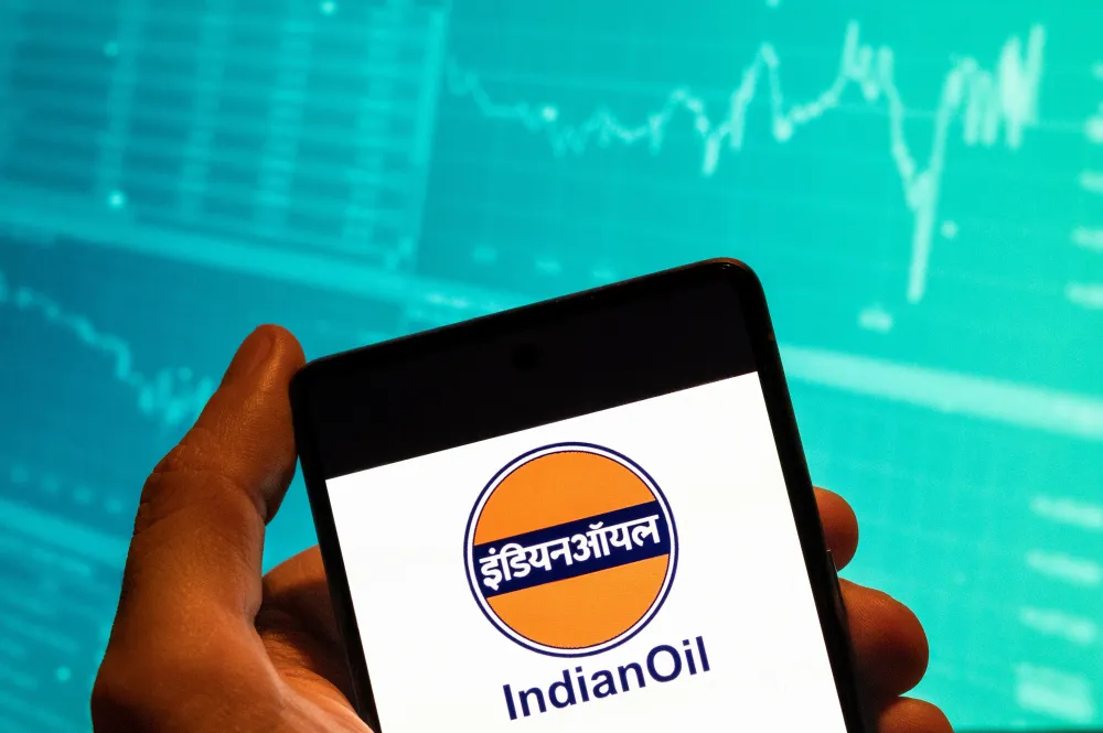 In this photo illustration, the Indian Oil company logo seen displayed on a smartphone with an economic stock exchange index graph in the background. (Photo Illustration by Budrul Chukrut/SOPA Images/LightRocket via Getty Images)