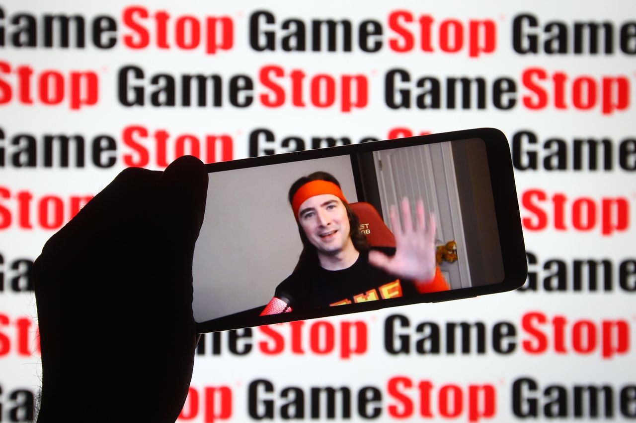 Keith Gill, known on Reddit under the pseudonym DeepFuckingValue and as Roaring Kitty, is seen on a fragment of a youtube video displayed on a smartphone screen in front of GameStop logo. (Photo Illustration by Pavlo Gonchar/SOPA Images/LightRocket via Getty Images)