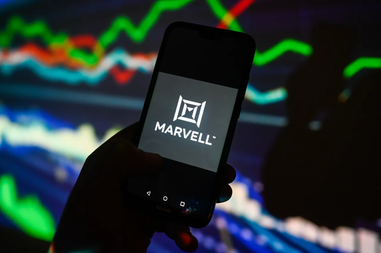 In this photo illustration, a Marvell logo is displayed on a smartphone with stock market percentages on the background