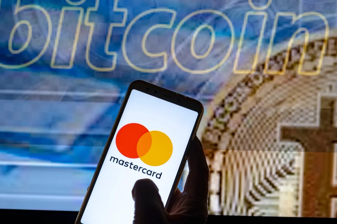 In this photo illustration the Mastercard logo is seen on the screen of a smartphone with a bitcoin cryptocurrency logo in the background. (Photo Illustration by Paco Freire/SOPA Images/LightRocket via Getty Images)