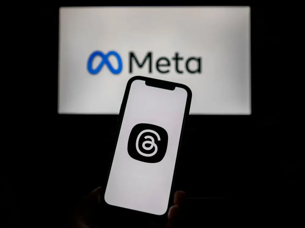 In this photo illustration, the Meta and Threads logos are seen on screens