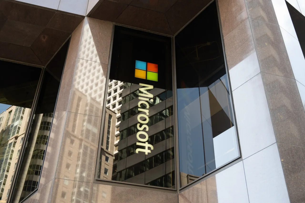 Microsoft logo in window of granite and glass office tower with reflections of surrounding buildings, San Francisco, California, May 13, 2025. (Photo by Smith Collection/Gado/Getty Images)