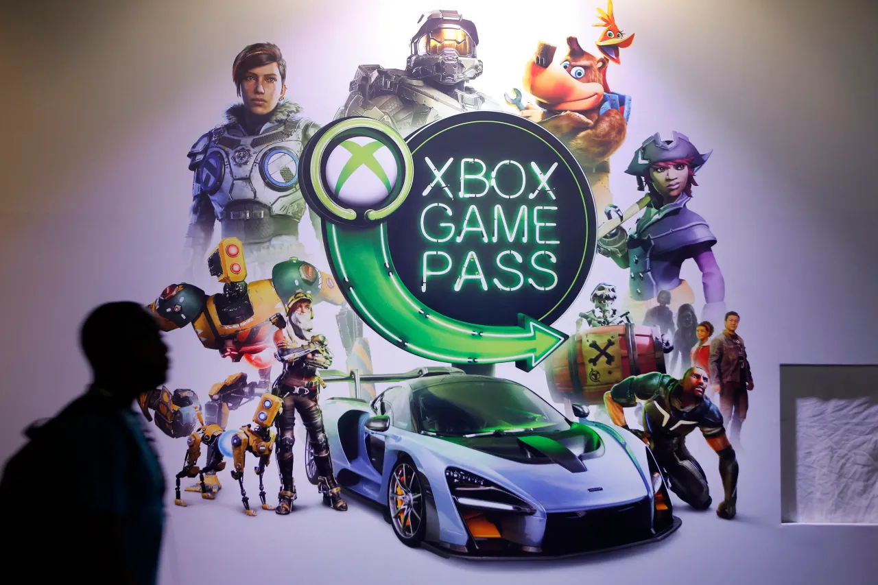 A visitor walks past an poster of the Microsoft subscription service "Xbox Game Pass" during the 'Paris Games Week' on October 25, 2018 in Paris, France