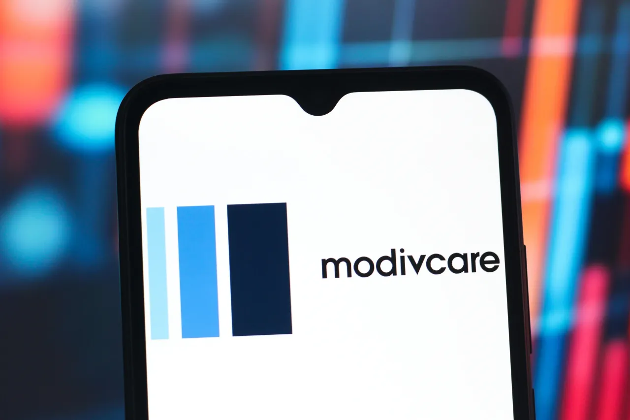 In this photo illustration, the ModivCare (Modiv Care) logo is seen displayed on a smartphone screen. (Photo Illustration by Thomas Fuller/SOPA Images/LightRocket via Getty Images)