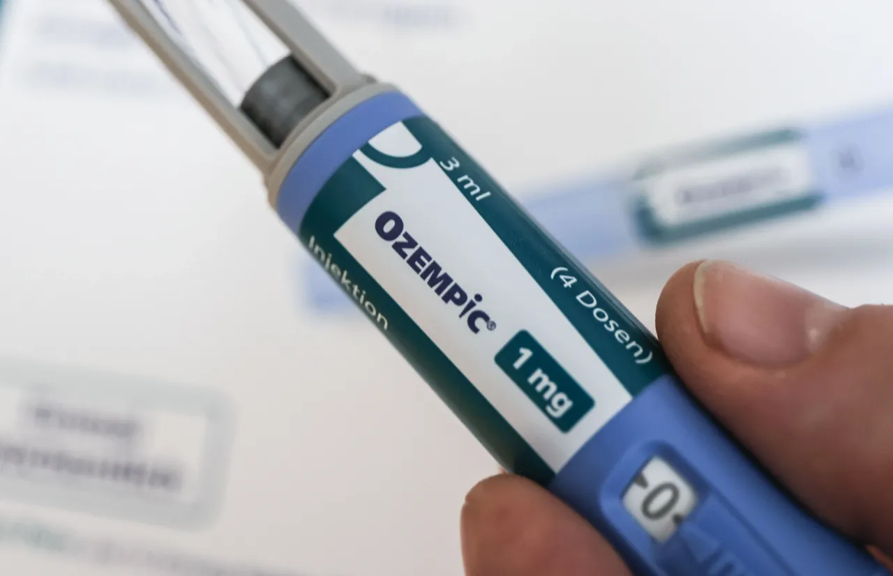 A man holds an Ozempic brand slimming syringe in his hand