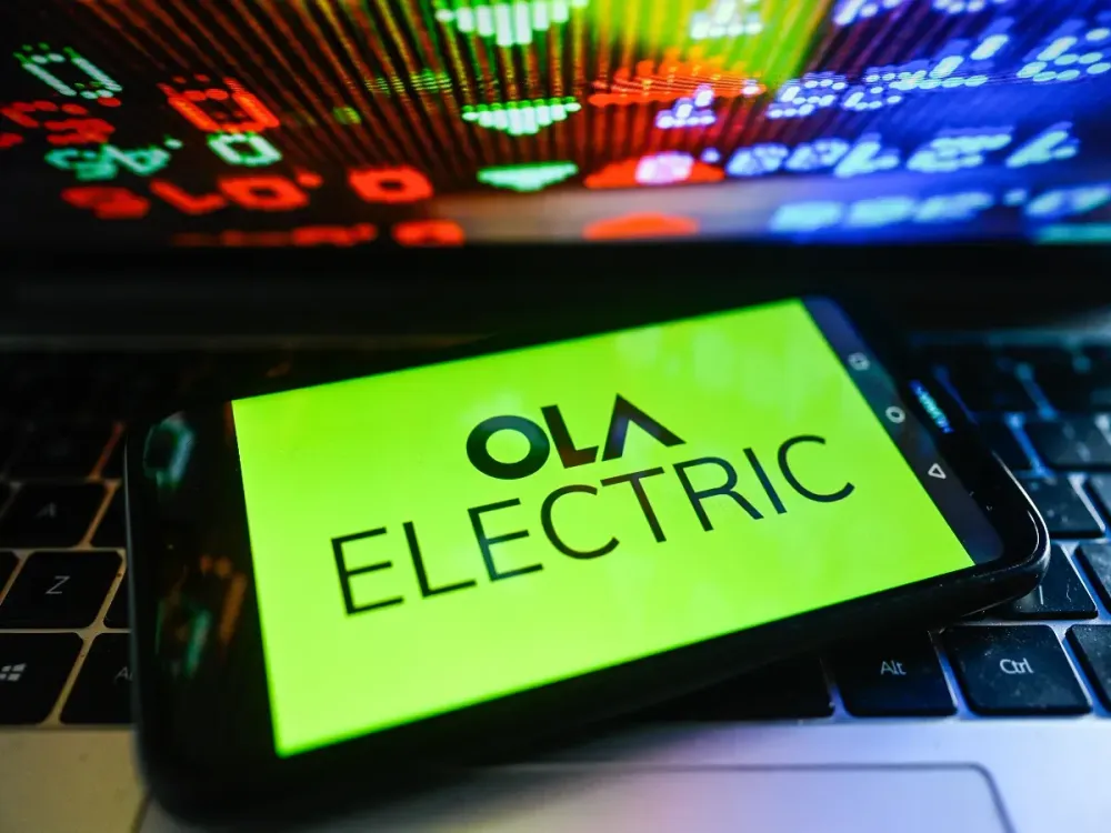In this photo illustration, an Ola Electric logo is displayed on a smartphone with stock market percentages on the background. (Photo Illustration by Omar Marques/SOPA Images/LightRocket via Getty Images)