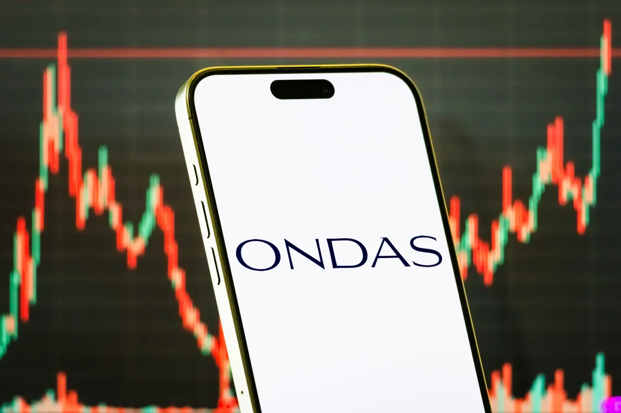 In this photo illustration, a smartphone displays the logo of Ondas Holdings Inc., in front of a screen showing the company's latest stock market chart on August 8, 2025 in Chongqing, China. (Photo illustration by Cheng Xin/Getty Images)