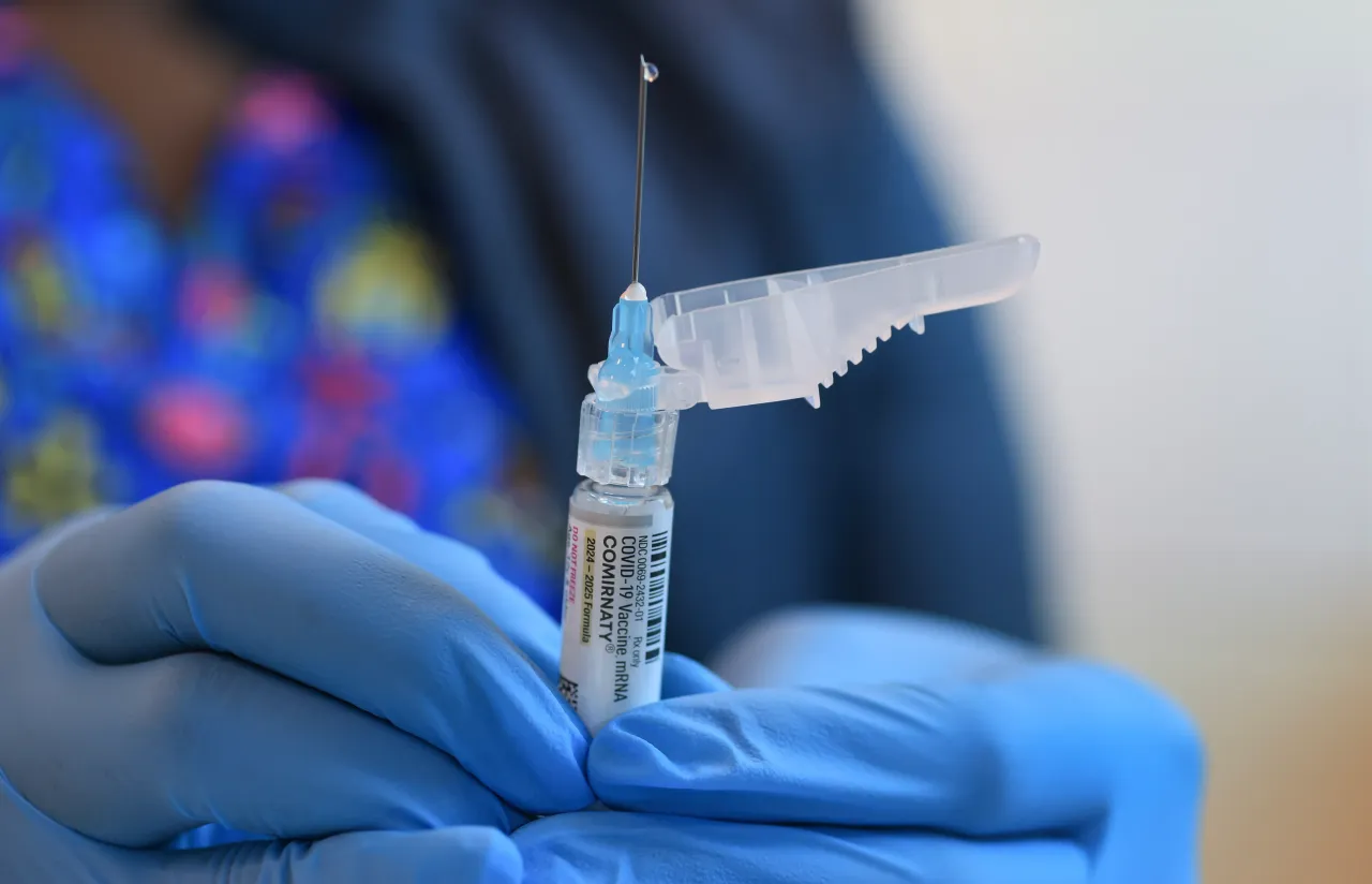 In this photo illustration, Ruth Jones, Immunization Nurse, holds a Pfizer-BioNTech COVID-19 vaccine (brand name: Comirnaty) at Borinquen Health Care Center on May 29, 2025 in Miami, Florida
