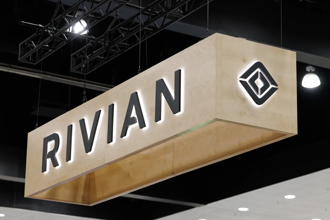 The Rivian logo is on display during the 2025 Los Angeles Auto Show at the Los Angeles Convention Center on November 23, 2025 in Los Angeles, California