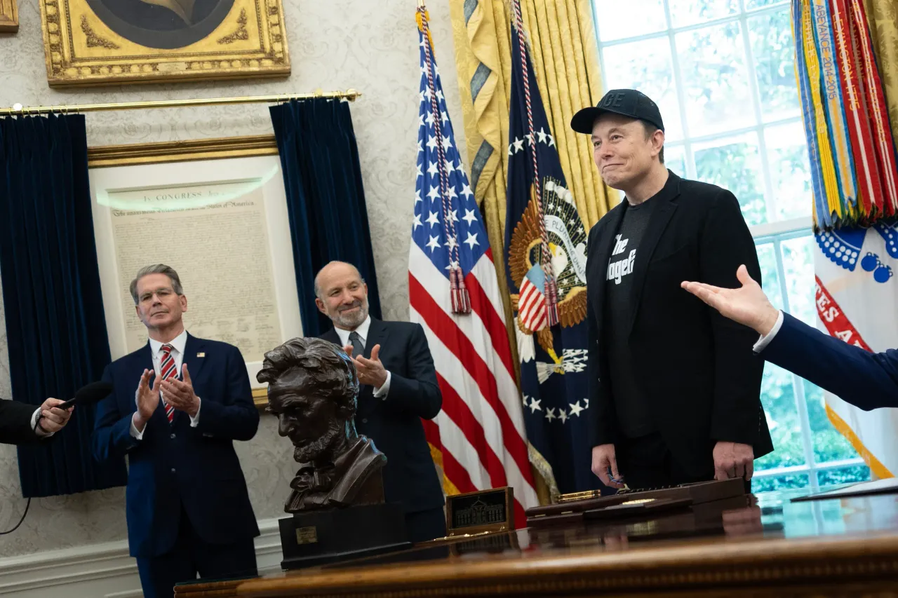 Treasury Secretary Scott Bessent and Commerce Secretary Howard Lutnick applaud for Elon Musk on May 30, 2025 inside the Oval Office at the White House in Washington