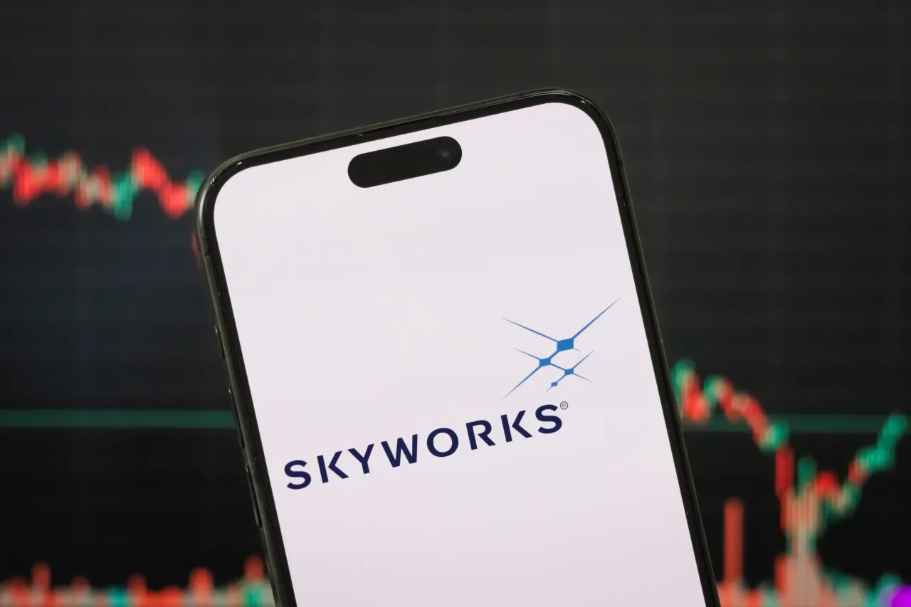 In this photo illustration, the logo of Skyworks Solutions, Inc. is displayed on a smartphone screen with a stock market chart in the background, on May 04, 2025, in Chongqing, China. (Photo illustration by Cheng Xin/Getty Images)