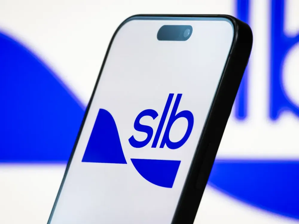 In this photo illustration, the SLB (Schlumberger) logo is displayed on a smartphone screen, with the company's blue branding visible in the background, on April 20, 2025, in Chongqing, China. (Photo illustration by Cheng Xin/Getty Images)