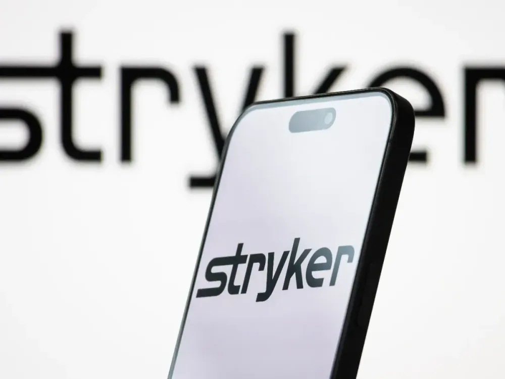 In this photo illustration, the logo of Stryker Corporation is displayed on a smartphone screen, with the company's branding visible in the background, on April 26, 2025, in Chongqing, China. (Photo illustration by Cheng Xin/Getty Images)