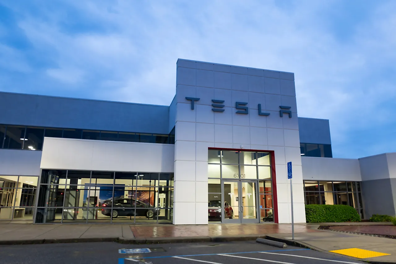 Facade with logo and sign at dusk at the Tesla Motors dealership in Pleasanton, California, March 12, 2018. (Photo by Smith Collection/Gado/Getty Images)