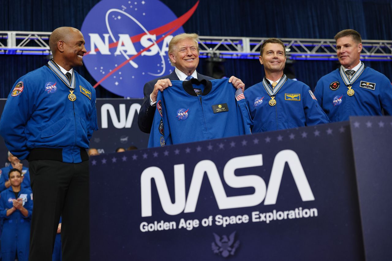 U.S. President Donald Trump (C) holds up a flight jacket gifted to him by the Artemis II crew at NASA's Johnson Space Center on August 28, 2026 in Houston, Texas. (Photo by Win McNamee/Getty Images)
