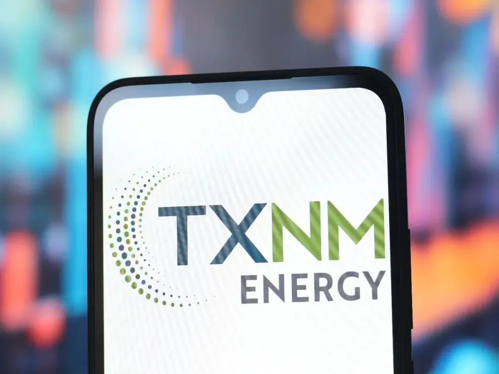 In this photo illustration, the TXNM Energy logo is seen displayed on a smartphone screen. (Photo Illustration by Thomas Fuller/SOPA Images/LightRocket via Getty Images)