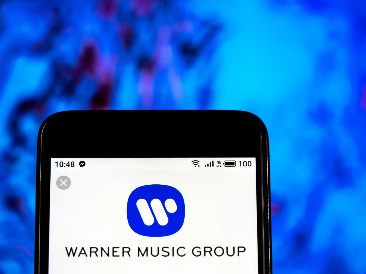 In this photo illustration, the Warner Music Group company logo seen displayed on a smartphone