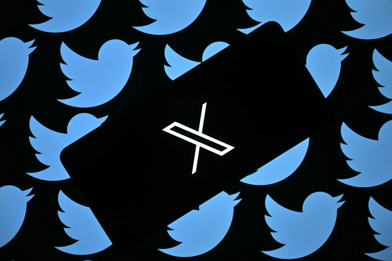 In this photo illustration, the new logo of 'Twitter' is displayed in front of a screen displaying the former logo of 'Twitter'.