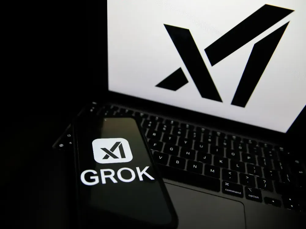 The Grok logo appears on a phone and the xAI logo is displayed on a laptop in Krakow, Poland, on April 1, 2025. (Photo by Klaudia Radecka/NurPhoto via Getty Images)