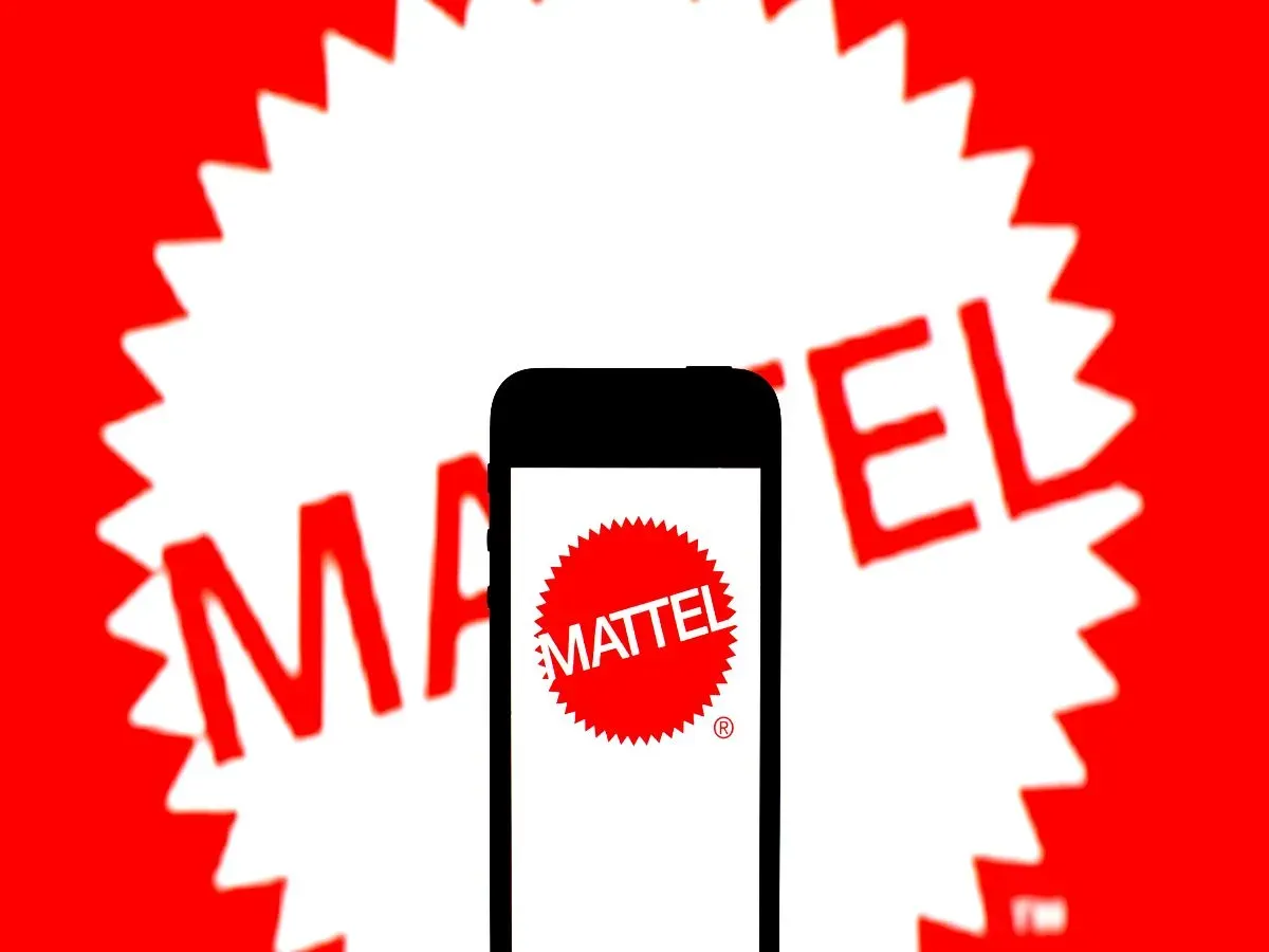  In this photo illustration, a Mattel Inc. logo seen displayed on a smartphone and in the background.