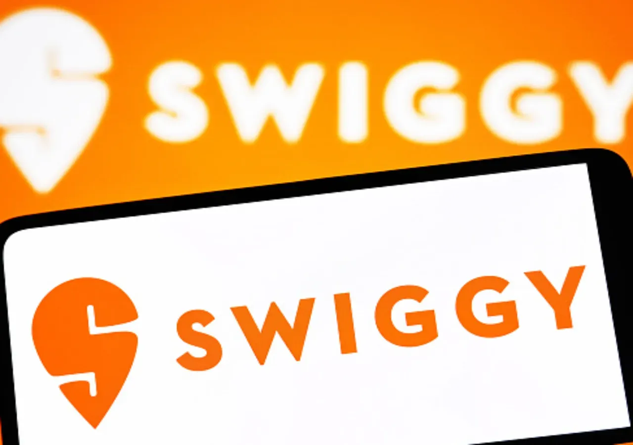  In this photo illustration, a Swiggy logo is seen on a smartphone and in the background. (Photo Illustration by Pavlo Gonchar/SOPA Images/LightRocket via Getty Images)